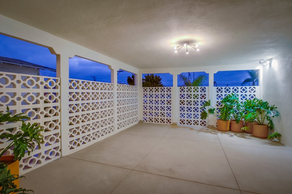 Restored mid-century breeze-block screen wall with sputnik light fixture and potted plants
